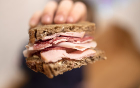 Stock Image: Child with a thick sausage bread in his hand