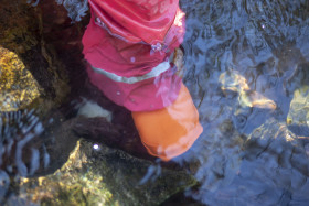 Stock Image: Child with rubber boots standing in a stream