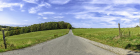 Stock Image: country road through rural landscape with field and blue sky, wuppertal ronsdorf, nrw germany