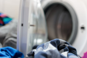 Stock Image: Dirty laundry in front of a washing machine