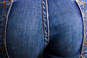 Stock Image: Female bottom in tight blue jeans background texture