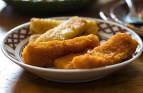 Stock Image: Fish fingers on a plate in a kitchen on a wooden table