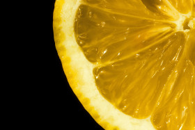 Stock Image: Fresh yellow lemon on black background, closeup