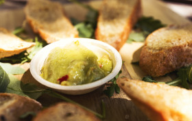 Stock Image: garlic baguette slices with guacamole dip