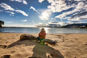 Stock Image: Girl sitting on the beach of Platja Grifeu by Girona in spain