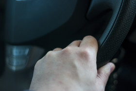 Stock Image: hand on the car steering wheel