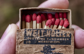 Stock Image: Hands holding a old vintage matchbox, closeup