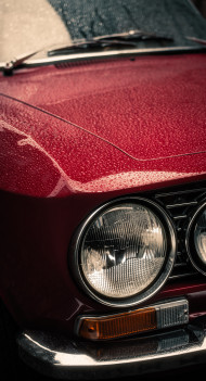 Stock Image: Headlights , radiator and hood of retro red car
