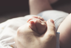 Stock Image: holding baby hand - baby care