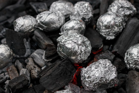 Stock Image: Jacket potato on glowing coals