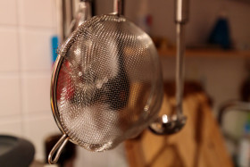 Stock Image: Kitchen colander hanging over the sink
