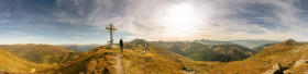 Stock Image: Landscape panorama of the Austrian Alps Hiker stands at the summit cross