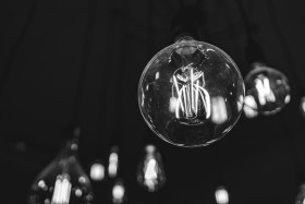 Stock Image: Light bulbs glow in the dark room black and white