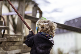 Stock Image: Little boy climbs on a rope in a playground