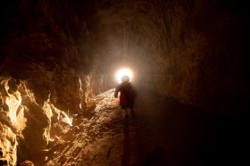 Stock Image: Little girl is running towards the light at the end of the tunnel