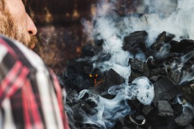 Stock Image: man lights barbecue