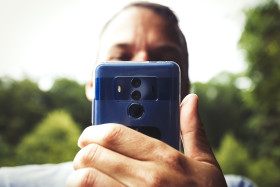 Stock Image: Man takes pictures with his smartphone