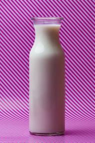 Stock Image: milk bottle on pink and white striped background
