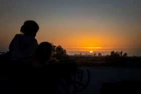 Stock Image: Mother and daughter watch the sunset on the beach