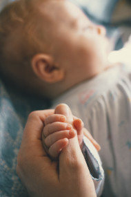 Stock Image: Newborn baby hand - baby care
