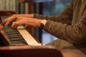 Stock Image: Old hands play the piano