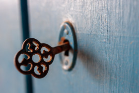 Stock Image: Old key in a blue door