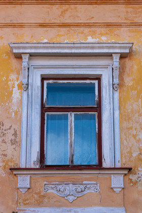 Stock Image: Old window in crumbling yellow wall