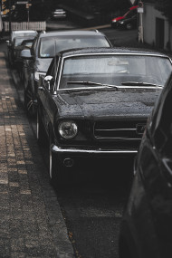 Stock Image: oldtimer ford mustang wet in a parking slot