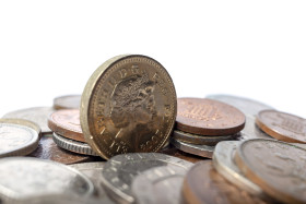 Stock Image: One british pound coin and a stack of small change isolated on white background