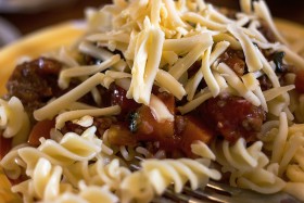 Stock Image: pasta with tomato and mince sauce and a lot of cheese