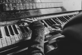 Stock Image: Pianist plays on an old destroyed piano