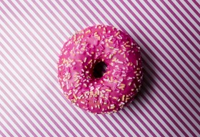 Stock Image: pink frosting donut on pink striped background
