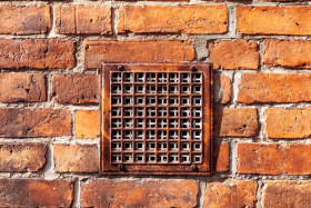 Stock Image: Red brick wall with a built-in ventilation duct texture background