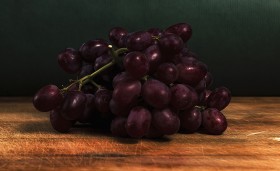 Stock Image: red grapes on a wooden board in a kitchen