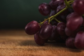 Stock Image: red grapes on a wooden board in a kitchen