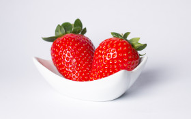 Stock Image: Red ripe strawberry in the white bowl, light background