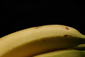Stock Image: ripe yellow bananas on black background with copy space