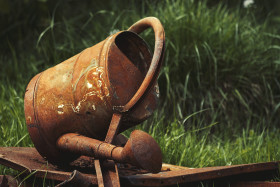 Stock Image: rusty old watering can in grass
