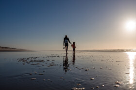 Stock Image: silhouette of a mother with her children on the beach in portugal nazare