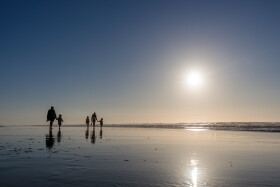 Stock Image: silhouette of family with children on the beach in portugal nazare