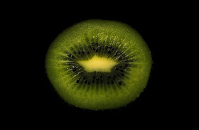 Stock Image: Slice of a kiwi fruit on a black background