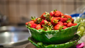 Stock Image: Strawberries in a green bowl in the kitchen