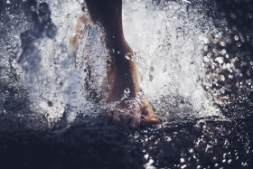 Stock Image: summer cooling fountain water splash - feet in the water