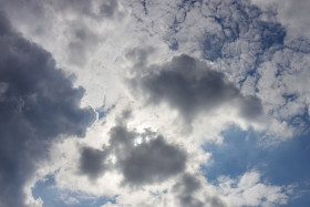 Stock Image: Sun behind white Clouds on a blue Sky for sky replacement
