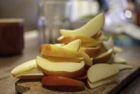 Stock Image: Thin apple slices in a kitchen on a wooden board