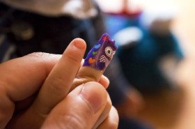 Stock Image: Toddler needs a doctor who wraps a patch around his finger