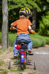 Stock Image: Toddler sits on bike with training wheels