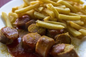 Stock Image: Traditional German currywurst - pieces of sausage with curry sauce