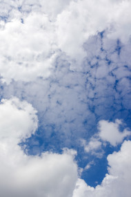 Stock Image: Vertical shot of a blue sky with white clouds for sky replacement