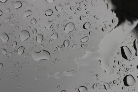 Stock Image: water droplets beading on a gloss black surface of a car